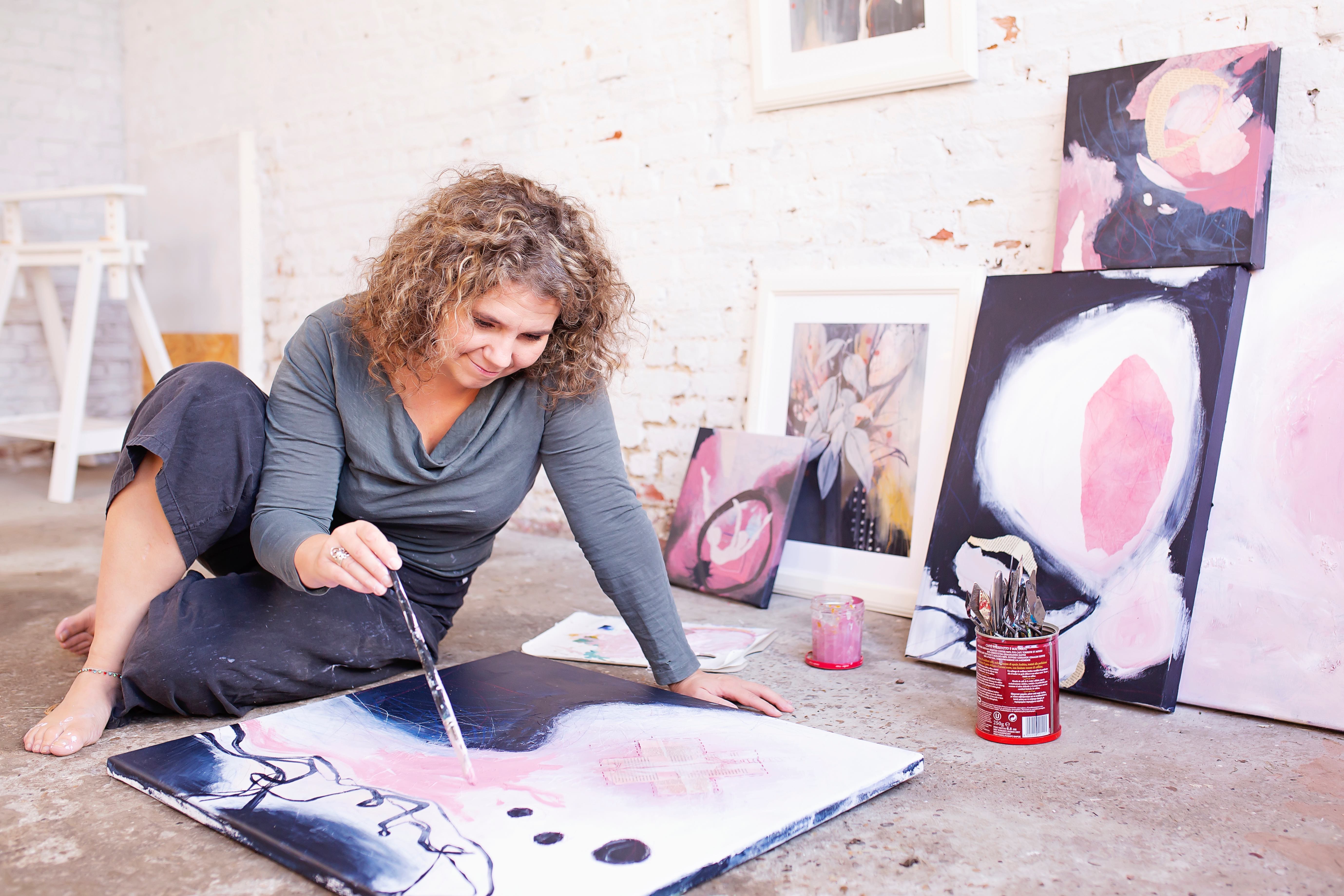 Mieke painting in her studio, fully immersed in the creative alchemy process